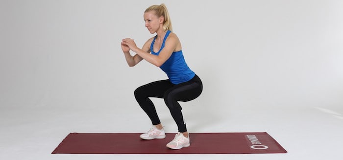 Frau macht Training für den Po, Squat auf roter Trainingsmatte