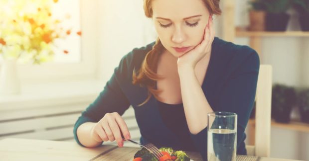 Frau stochert lustlos im Salat