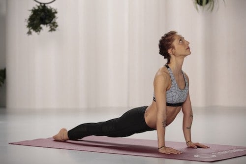 Frau macht Yoga heraufschauender Hund auf roter trainingsmatte