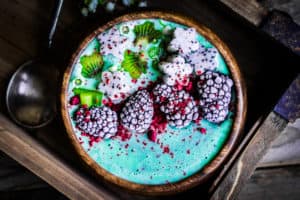 Bowl mit Spirulina Brei und geforenen Brombeeren