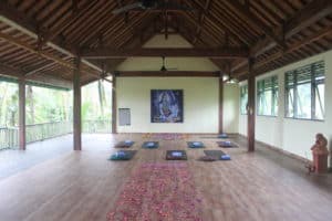 Yogamatten liegen in einem offenen Yogaraum auf Bali