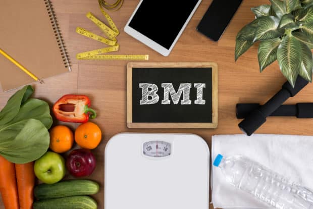 Körperwaage, Gemüse und eine Tafel mit der Aufschrift BMI