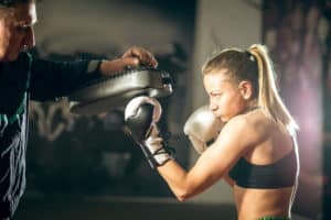 Junge Frau hochkonzentriert macht Boxtraining