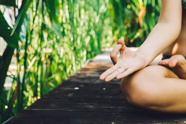 Das Knie und die Hand einer Frau im Lotussitz die Yoga macht auf Bali